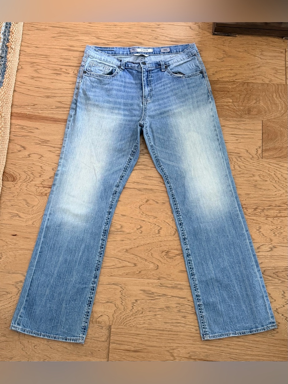 Distressed in spots, BKE Men’s Light Blue Bootcut Jeans